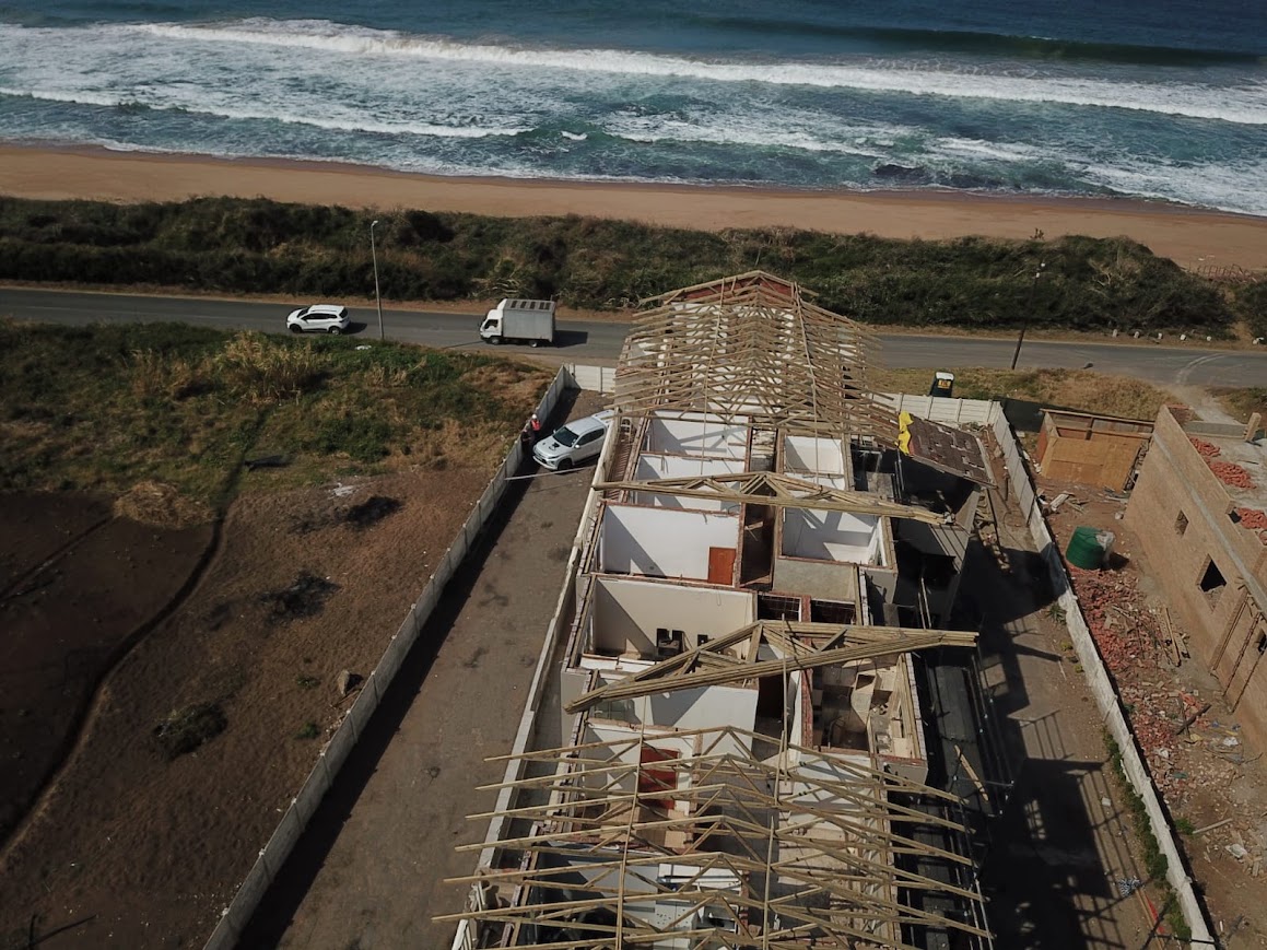 Aerial view of a coastal residential building during roof construction